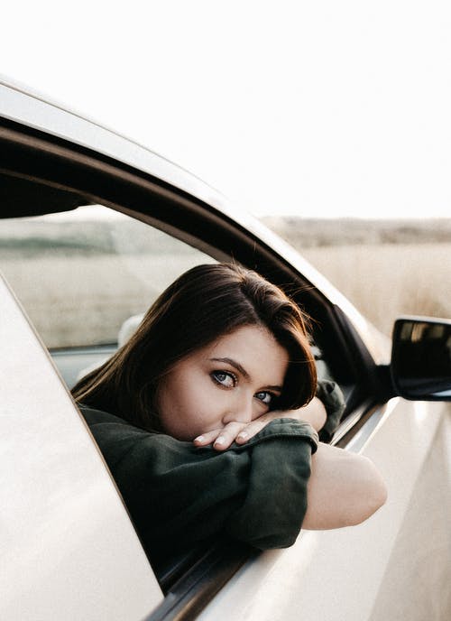 holka vyhlížející z okna auta